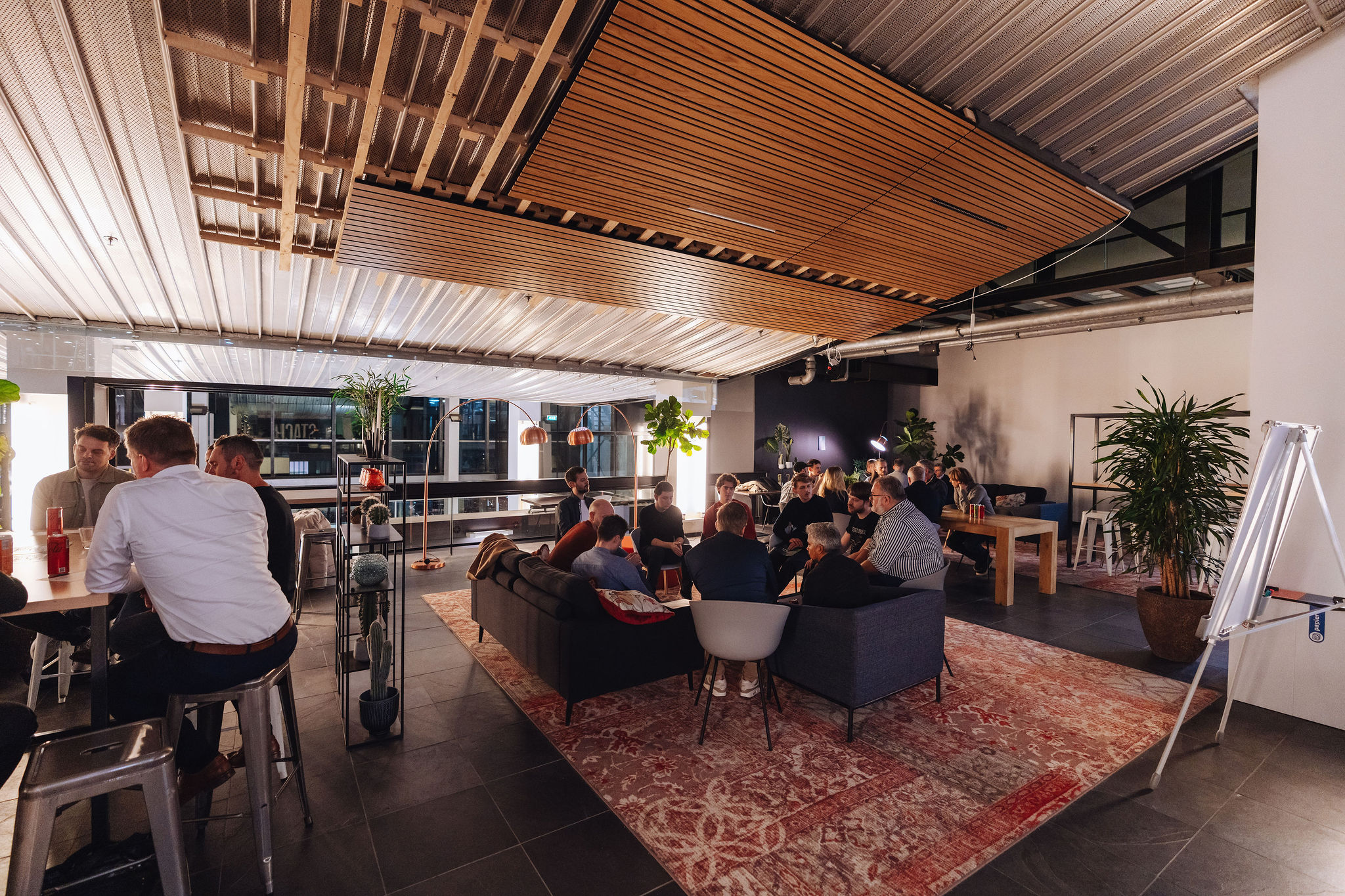 Mensen ontmoeten elkaar tussen hout en groen tijdens een Innovation Network meetup